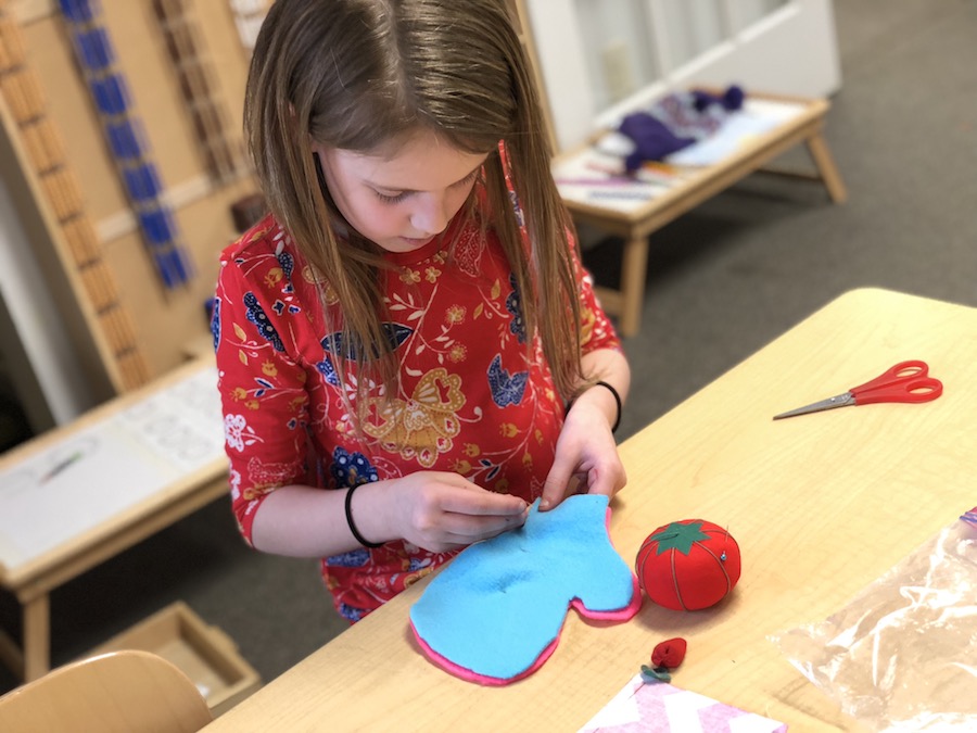 A McGuffey student sewing during a hands-on lesson