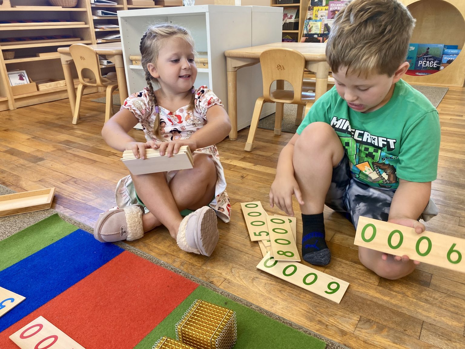 A young student working with Montessori bead materials on a rug
