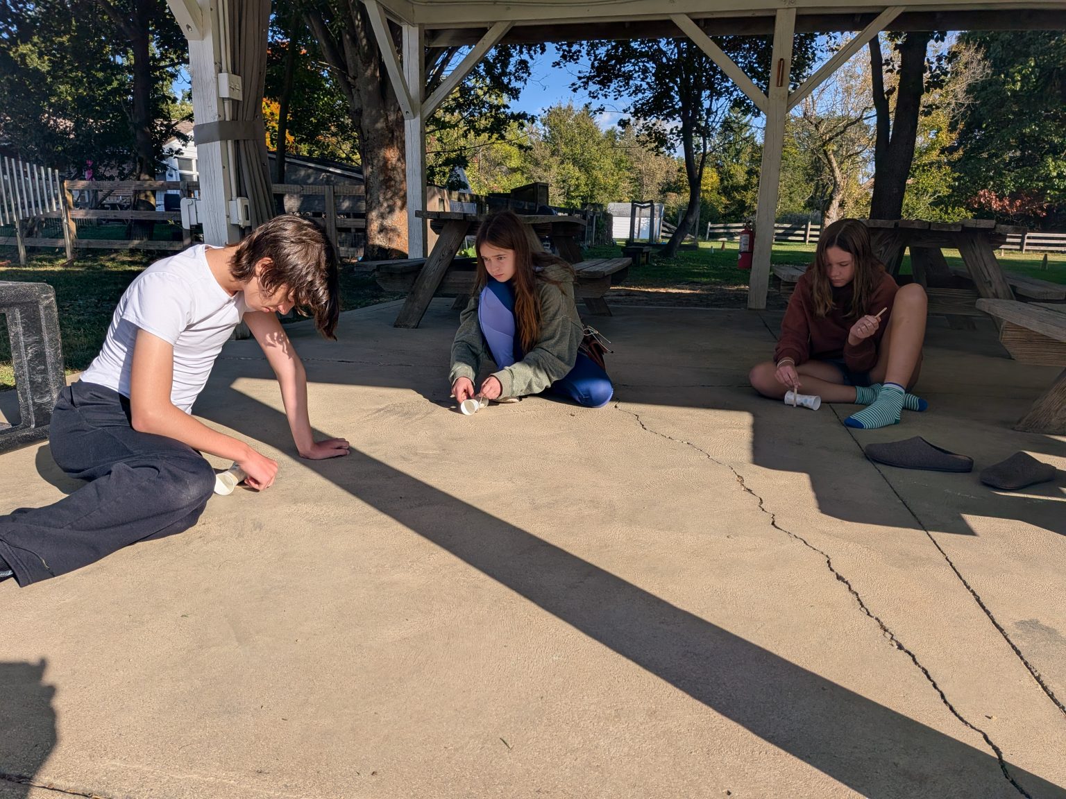 Students drawing with chalk under the picnic shelter